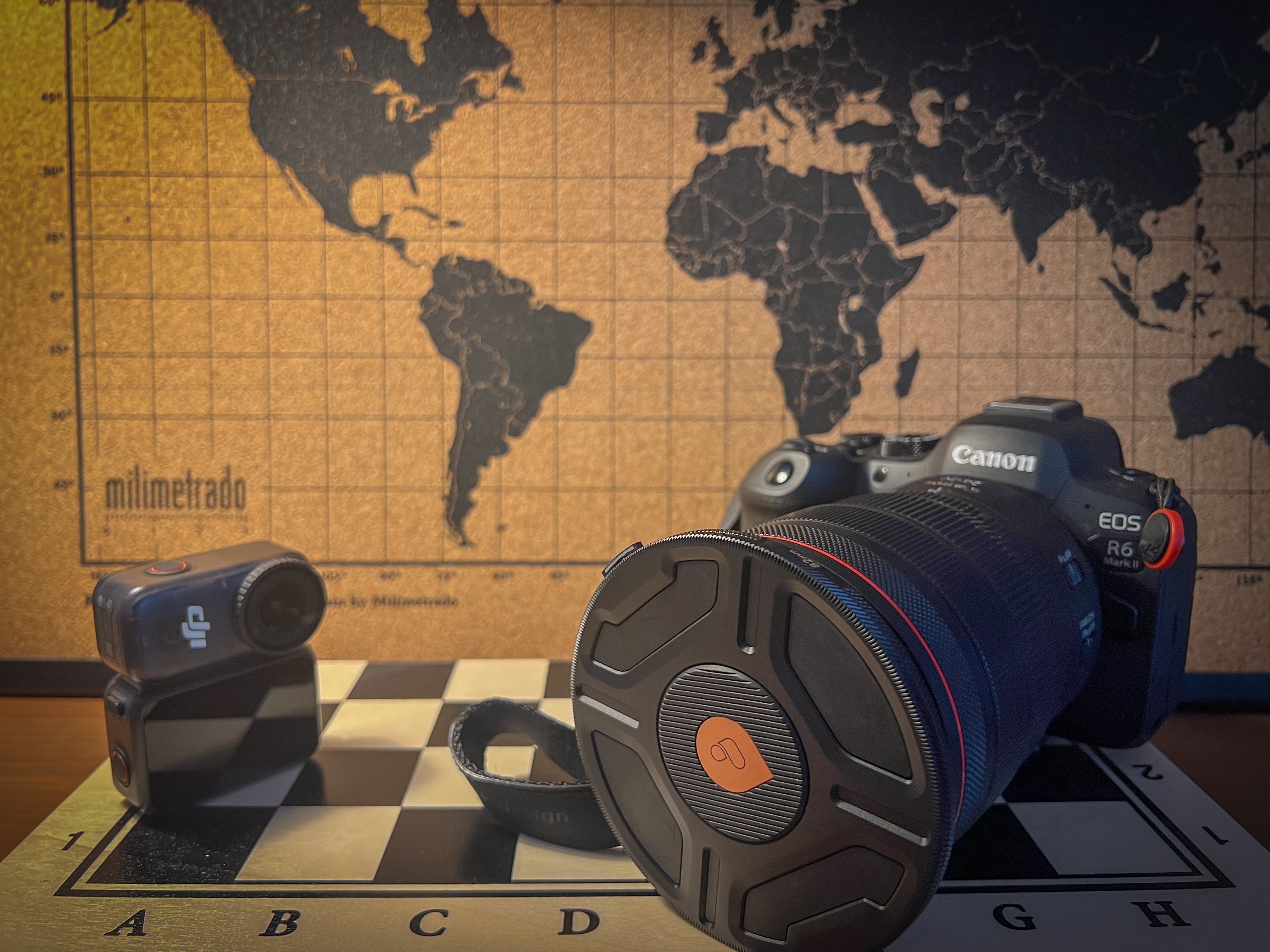 DJI Osmo Nano and Canon R6 Mark II side by side on top of a chess board and a world map on the background